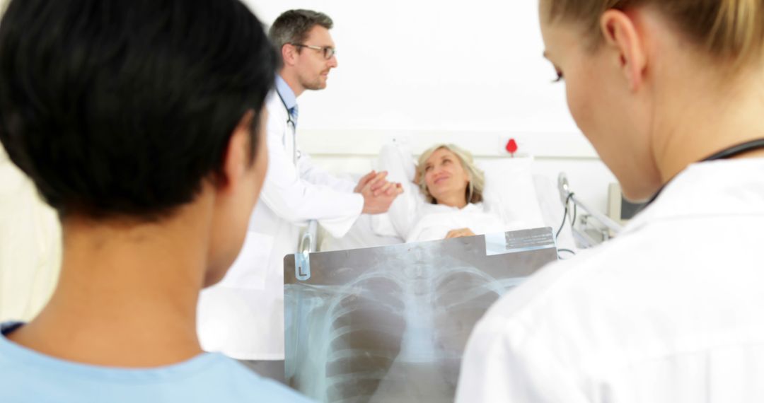 Doctors Analyzing X-Ray While Comforting Hospitalized Elderly Patient - Free Images, Stock Photos and Pictures on Pikwizard.com