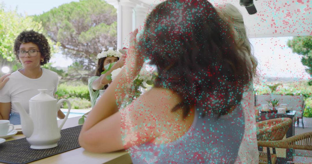 Women enjoying casual outdoor tea party on shaded veranda, candid summer gathering