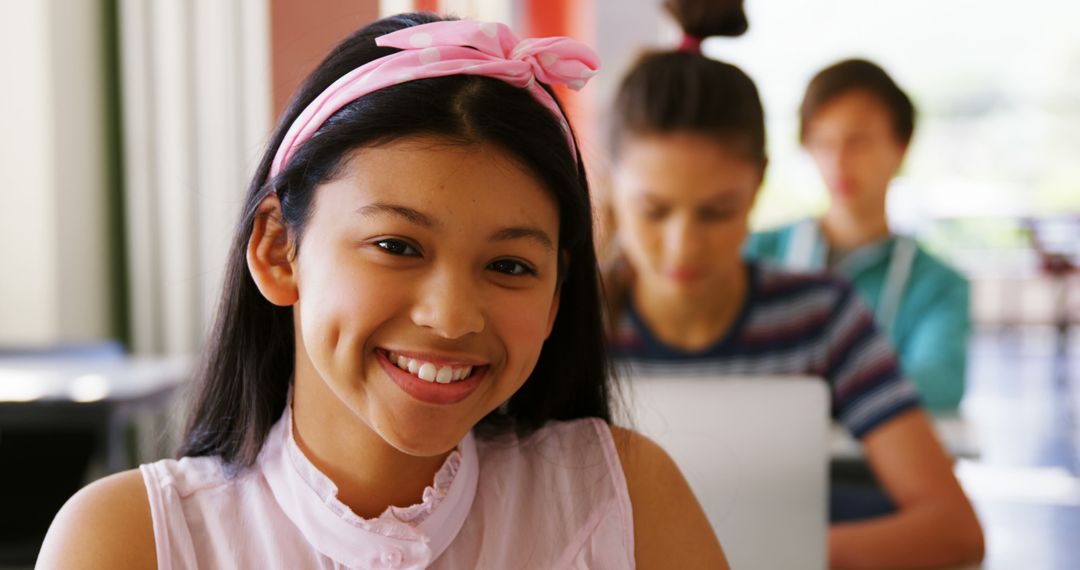 Smiling Teenage Girl in Classroom with Peers Studying in Background - Free Images, Stock Photos and Pictures on Pikwizard.com