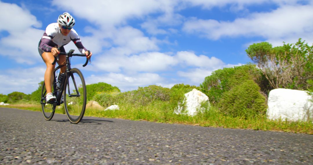 Cyclist Riding on Scenic Road in Sunny Weather - Free Images, Stock Photos and Pictures on Pikwizard.com