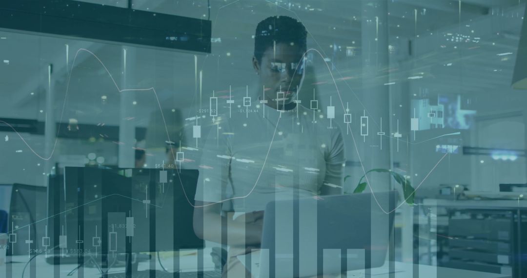 Man Analyzing Financial Charts on Laptop in Modern Office