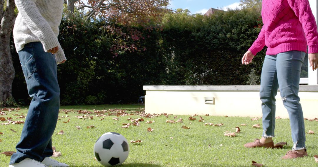 Mother and Son Playing Soccer in Garden on Sunny Autumn Day