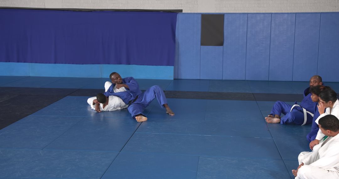 Martial Arts Instructor Demonstrating Ground Choke Hold Technique at Dojo