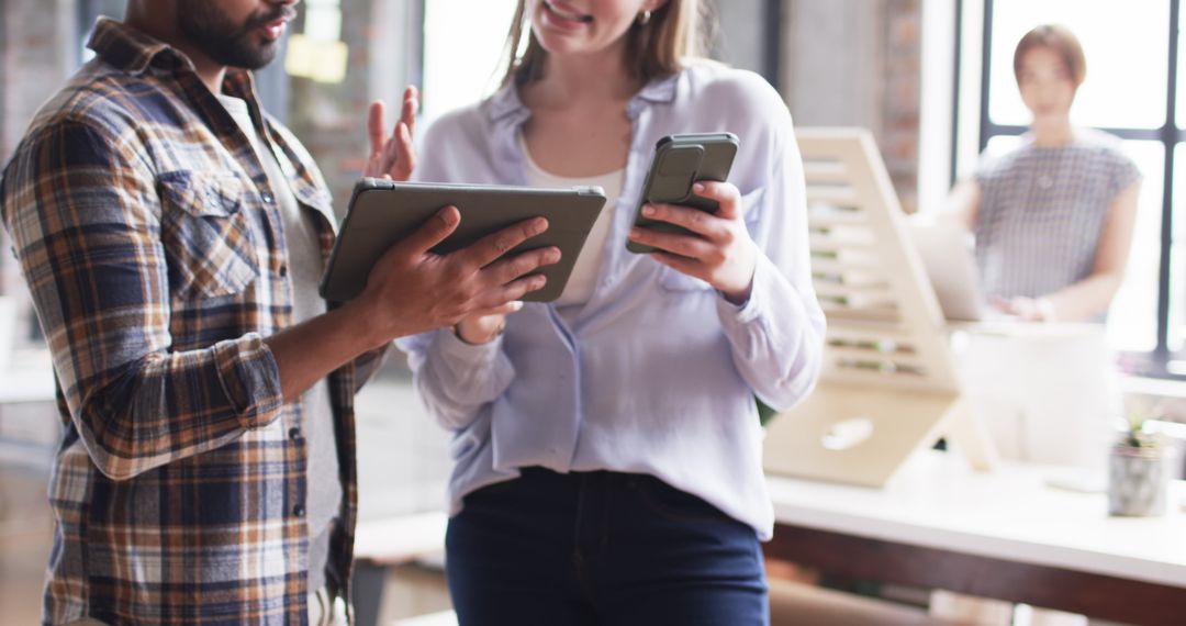 Diverse Colleagues Discussing Strategy with Digital Devices in Office