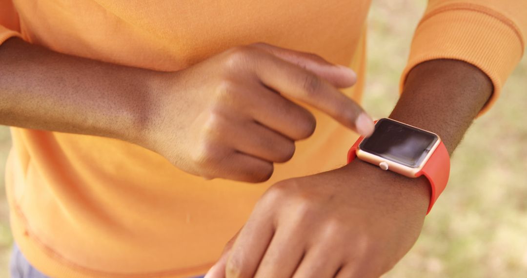 Person Using Smartwatch Outdoors with Vibrant Background - Free Images, Stock Photos and Pictures on Pikwizard.com