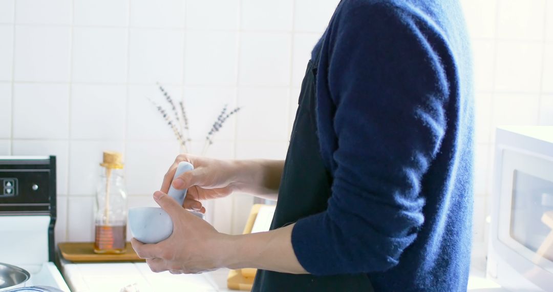 Man Using Mortar and Pestle in Kitchen for Spices Preparation - Free Images, Stock Photos and Pictures on Pikwizard.com