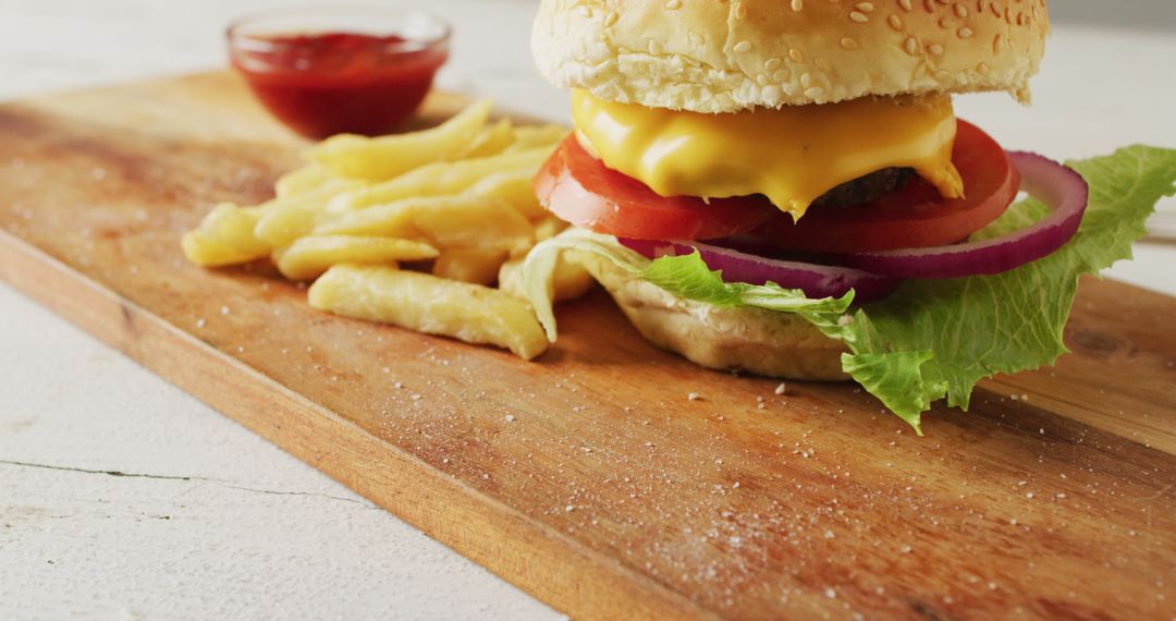 Close-Up of Cheeseburger and Fries on Wooden Board - Free Images, Stock Photos and Pictures on Pikwizard.com