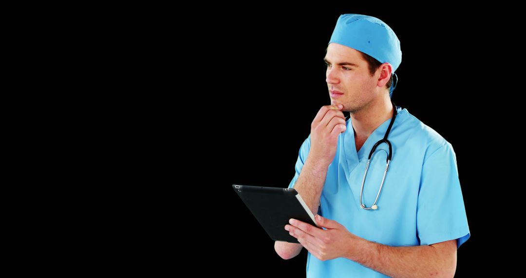 Young Doctor in Scrubs Using Tablet with Black Background - Free Images, Stock Photos and Pictures on Pikwizard.com