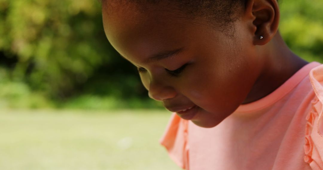 Little Girl Enjoying Digital Tablet in Green Park Setting