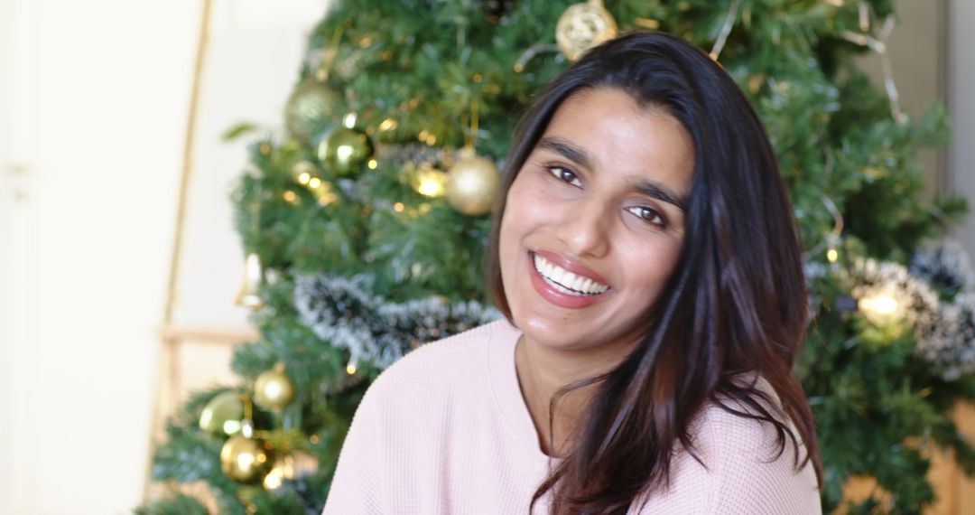 Joyful Woman in Cozy Sweater Smiling by Festive Christmas Tree