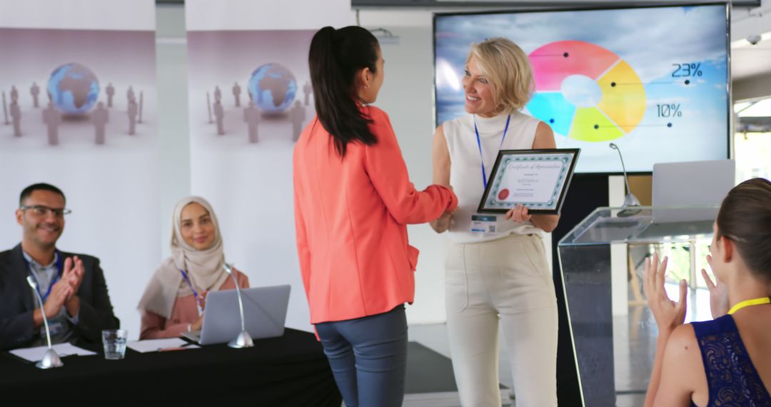 A businesswoman presents an award to a young Asian colleague at a conference. - Free Images, Stock Photos and Pictures on Pikwizard.com