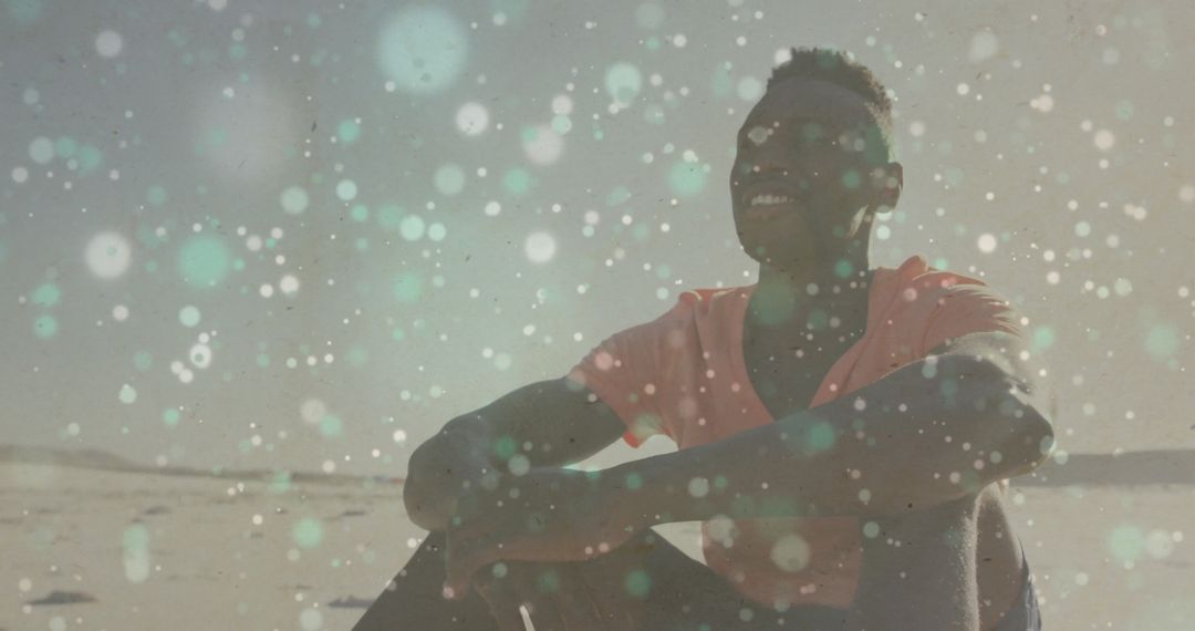 Man Smiling on Sandy Beach with Bokeh Lights and Blue Sky