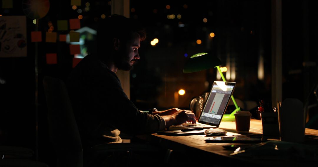 Focused Man Working Late Night on Laptop in Office - Free Images, Stock Photos and Pictures on Pikwizard.com