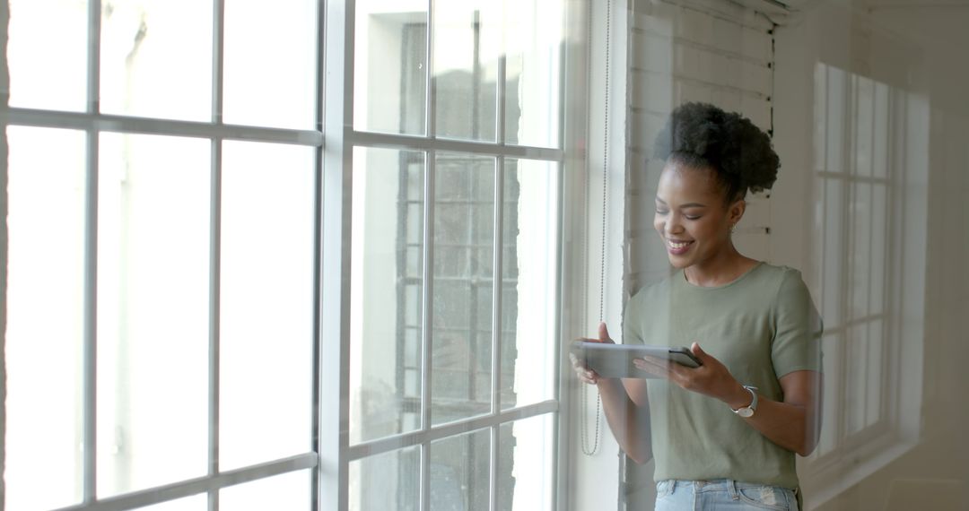 Joyful Businesswoman Using Tablet by Bright Window Light