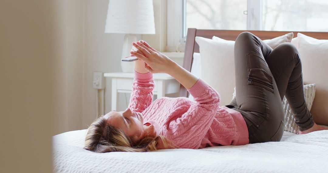 Woman Lying on Bed with Smartphone in Cozy Bedroom - Free Images, Stock Photos and Pictures on Pikwizard.com