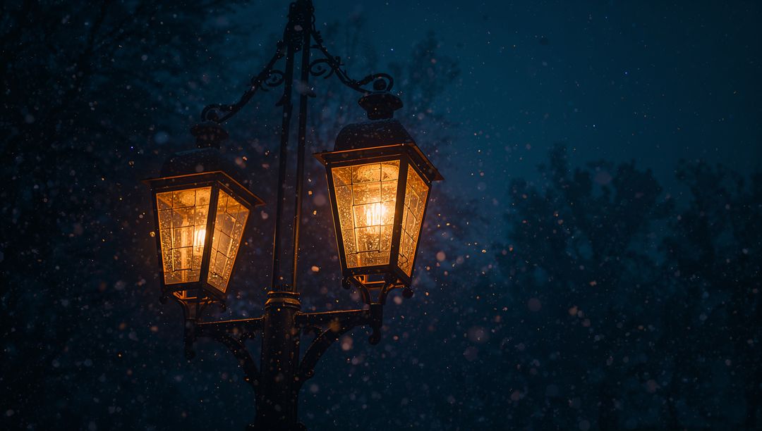 Victorian street lanterns glowing and casting warm light through falling snow at night