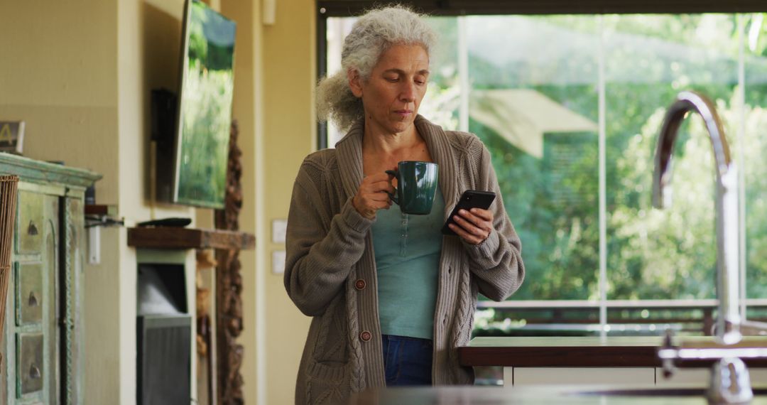 Senior Woman Using Smartphone and Drinking Coffee at Home - Free Images, Stock Photos and Pictures on Pikwizard.com