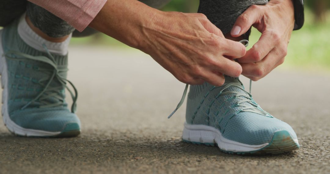 Person tying shoelaces on running shoes outdoors - Free Images, Stock Photos and Pictures on Pikwizard.com