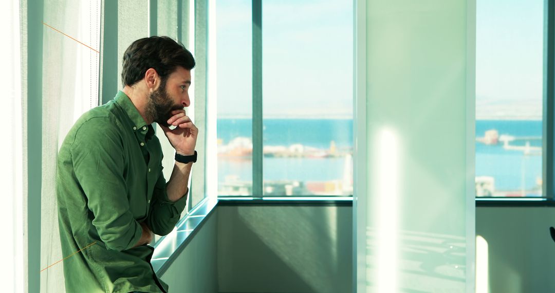 Thoughtful Mid Adult Man Near Window Overlooking Sea on Sunny Day - Free Images, Stock Photos and Pictures on Pikwizard.com