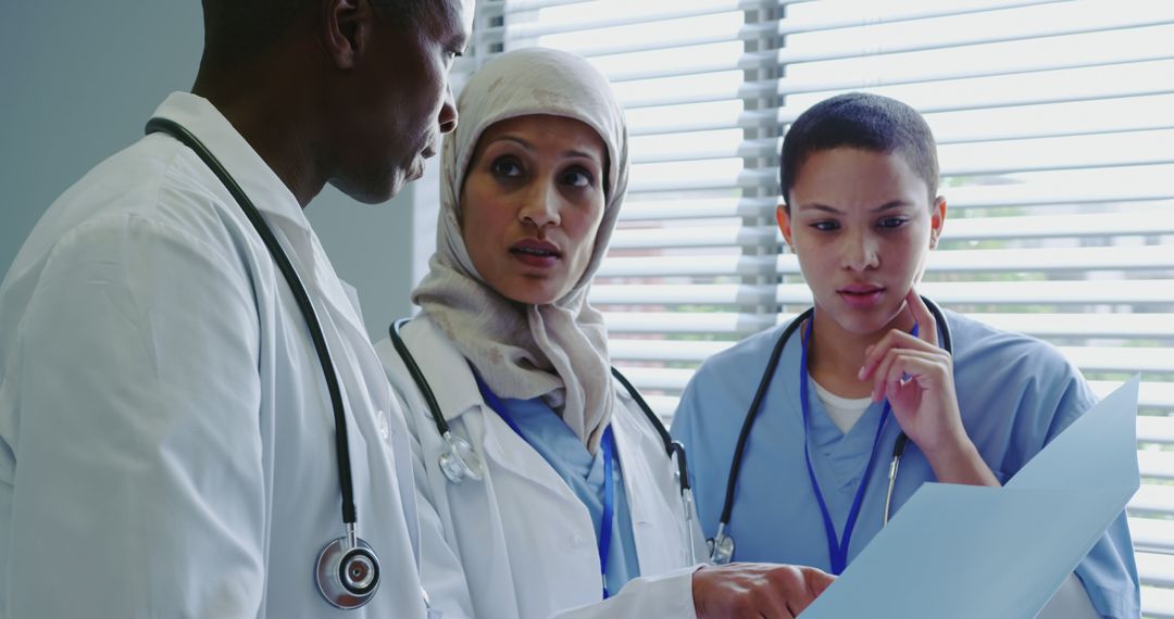 Diverse Medical Team Discussing Patient Records in Hospital Office - Free Images, Stock Photos and Pictures on Pikwizard.com