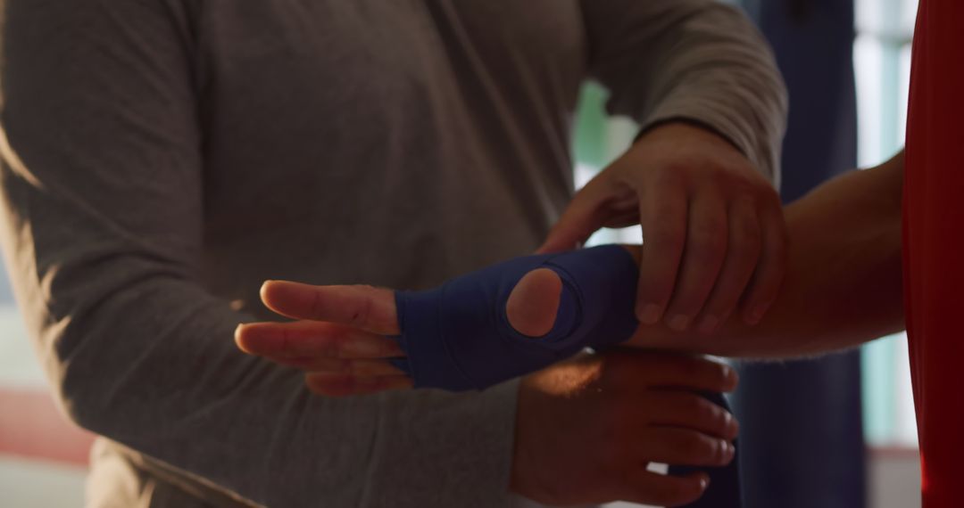 Trainer Wrapping Boxer's Hand with Blue Bandage - Free Images, Stock Photos and Pictures on Pikwizard.com