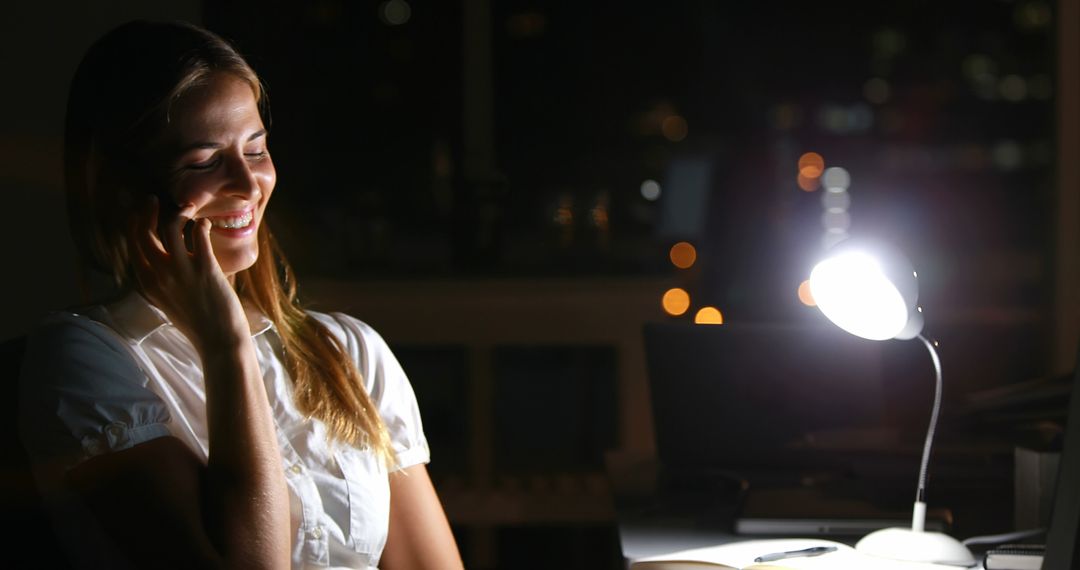 Woman Talking on Phone at Night Desk with Lamp Light - Free Images, Stock Photos and Pictures on Pikwizard.com