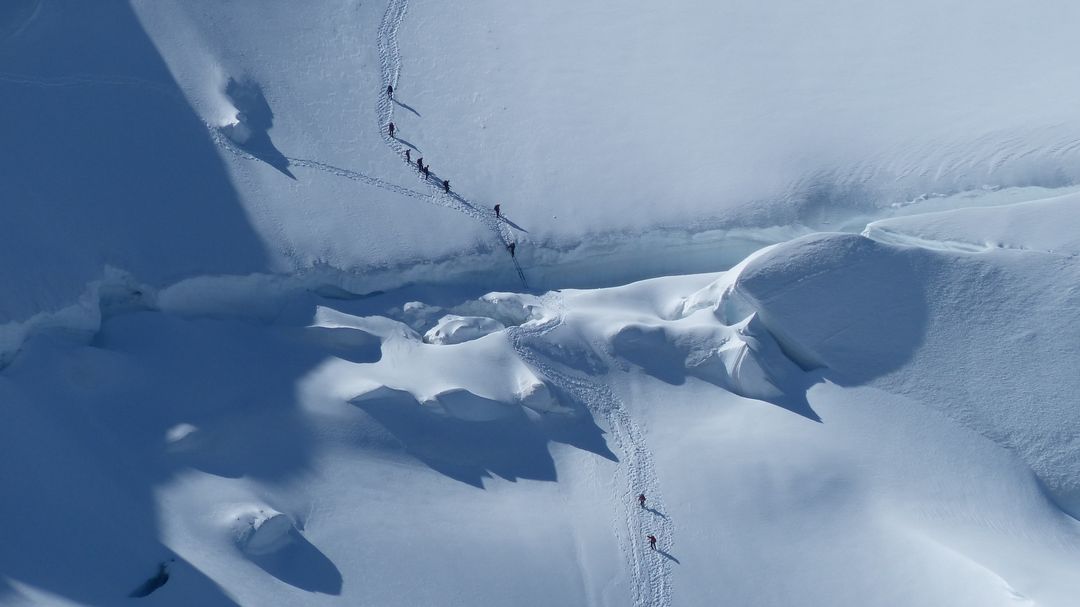 Aerial View of Climbers Traversing Snowy Mountain Crevasse - Free Images, Stock Photos and Pictures on Pikwizard.com