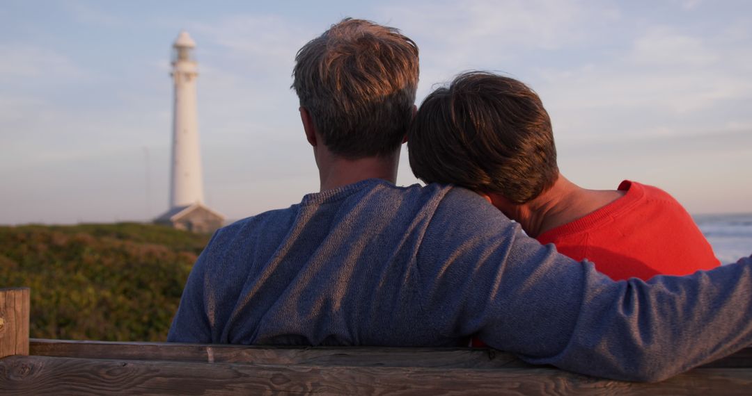 Senior Couple Embracing at Sunset by Lighthouse
