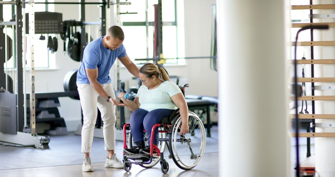 Trainer Assisting Woman with Disability Using Dumbbells in Gym