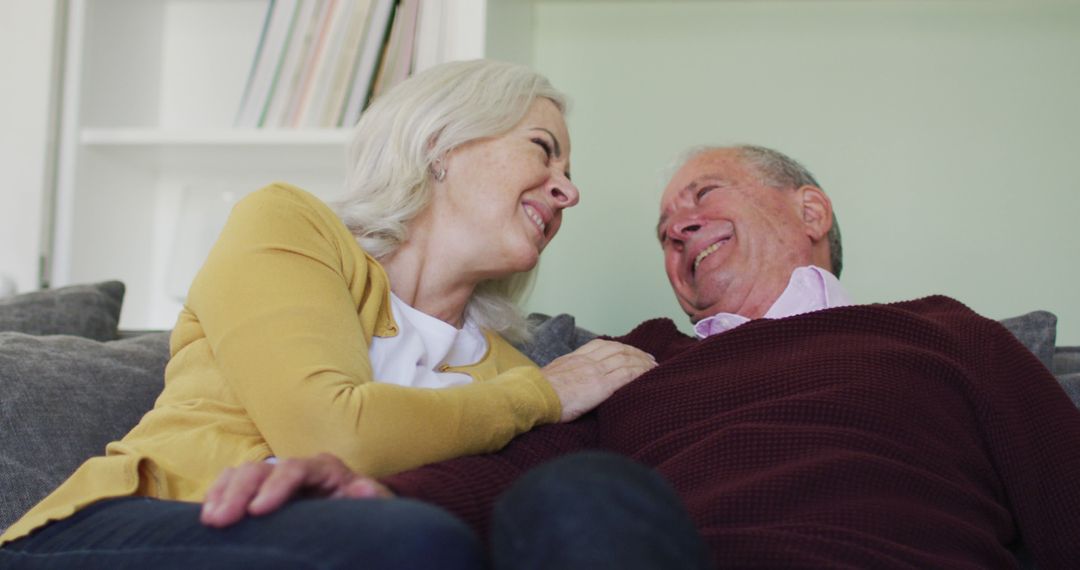 Senior Couple Laughing and Embracing on Couch