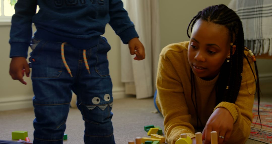 Woman and Child Playing with Wooden Building Blocks at Home - Free Images, Stock Photos and Pictures on Pikwizard.com