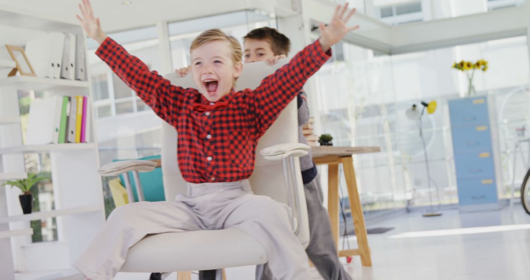 Children Playing in Office on Rolling Chair - Free Images, Stock Photos and Pictures on Pikwizard.com