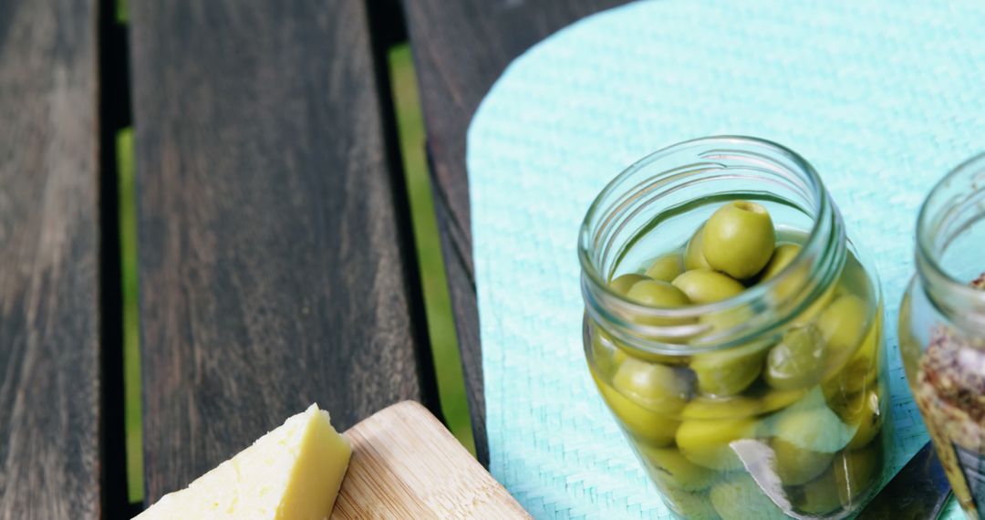 Jar of Green Olives and Cheese on Wooden Table - Free Images, Stock Photos and Pictures on Pikwizard.com