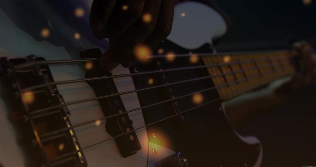 Musician Playing Bass Guitar Strings with Magical Bokeh Effect