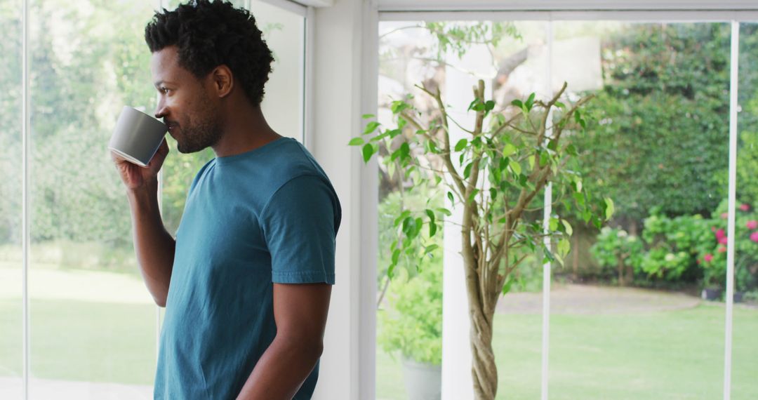 Man Drinking Coffee and Enjoying Scenic Garden View from Modern Home