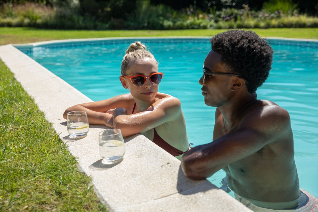 Diverse Couple Relaxing by Backyard Pool with Refreshing Drinks