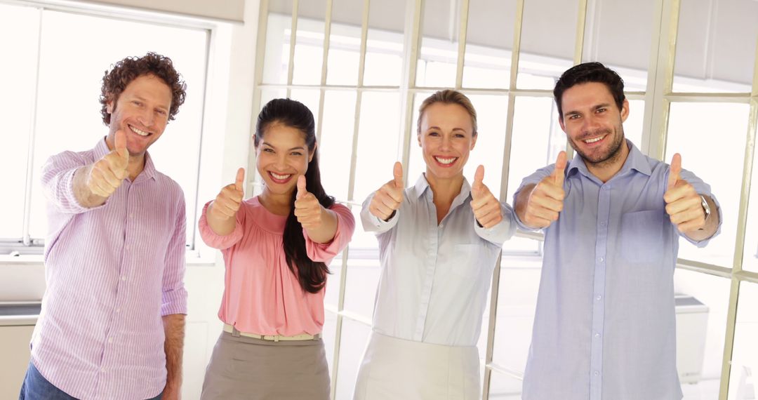 Business Team Giving Thumbs Up in Bright Office - Free Images, Stock Photos and Pictures on Pikwizard.com