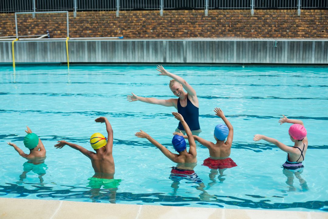 Female Instructor Teaching Children Swimming Techniques in Pool - Free Images, Stock Photos and Pictures on Pikwizard.com