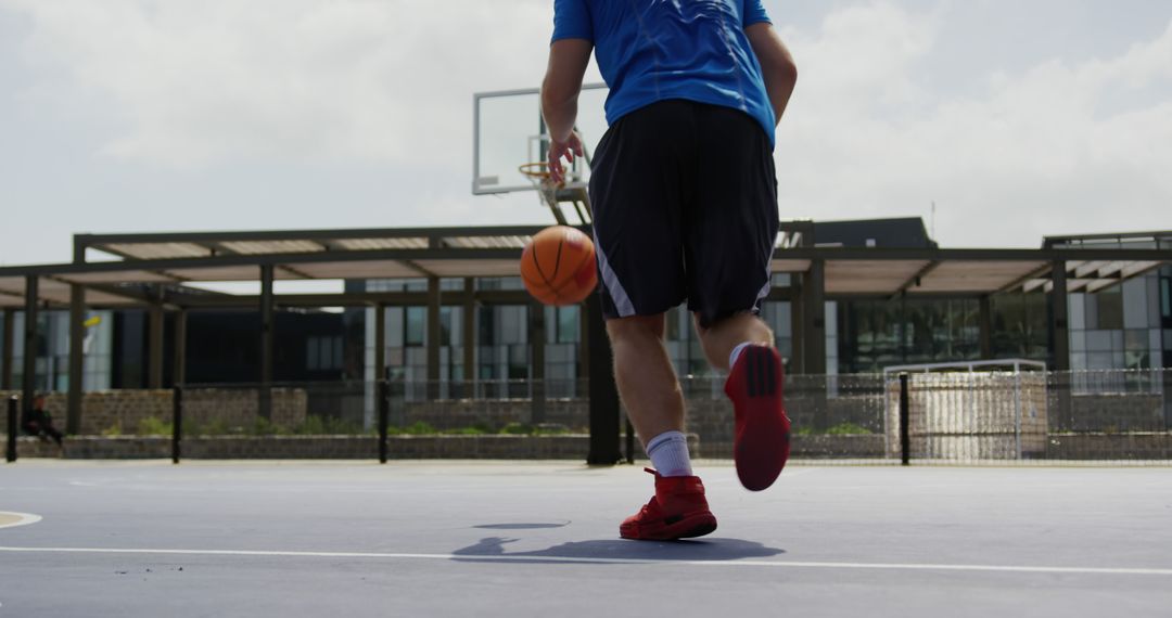 Young Athlete Dribbling Basketball on Outdoor Court - Free Images, Stock Photos and Pictures on Pikwizard.com