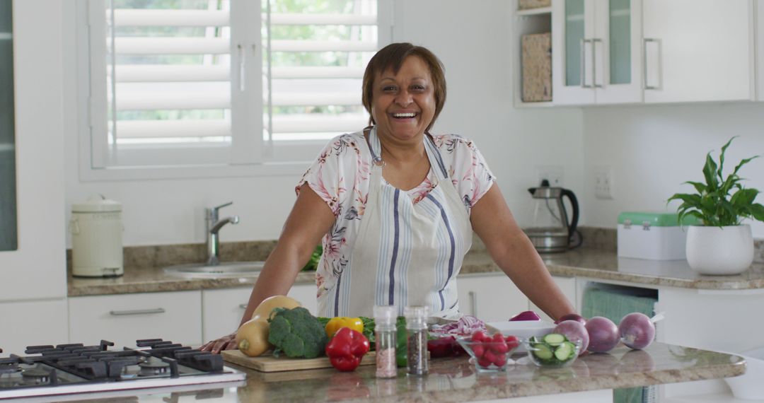 Smiling Senior Woman Preparing Vegetables in Modern Kitchen - Free Images, Stock Photos and Pictures on Pikwizard.com