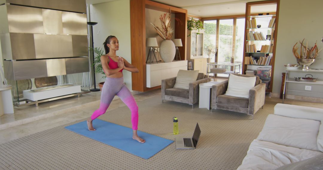 Fit woman practicing yoga at home with laptop guidance - Free Images, Stock Photos and Pictures on Pikwizard.com