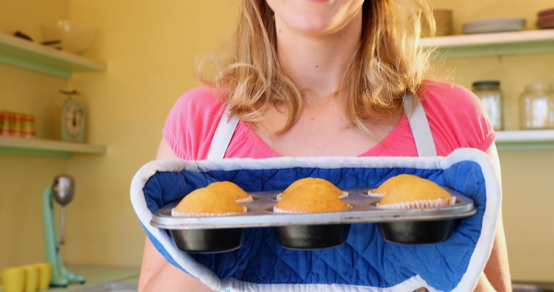 Woman Holding Freshly Baked Muffins in Kitchen - Free Images, Stock Photos and Pictures on Pikwizard.com