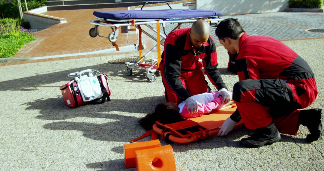 Paramedics rescuing young girl with stretcher on pavement - Free Images, Stock Photos and Pictures on Pikwizard.com