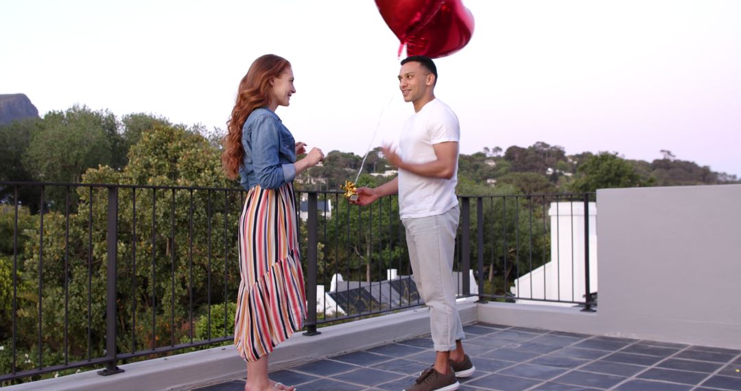 Man Proposing with Heart Balloons on Rooftop Deck