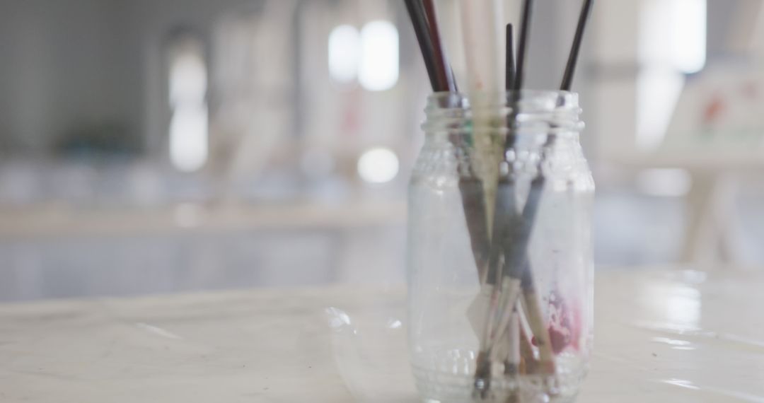 Artistic Paintbrushes Standing in Glass Jar on Table - Free Images, Stock Photos and Pictures on Pikwizard.com