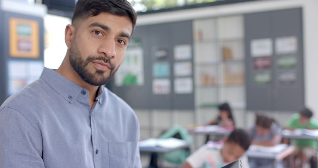 Male Teacher Using Tablet in Active Classroom Environment