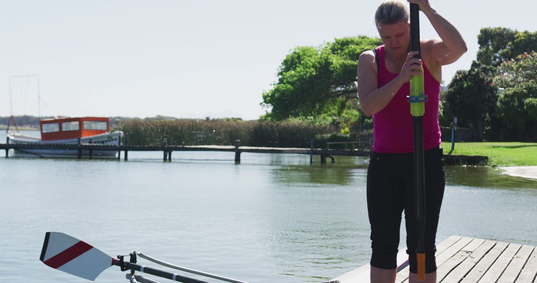 Female Athlete Preparing for Rowing Training on Dock Side - Free Images, Stock Photos and Pictures on Pikwizard.com