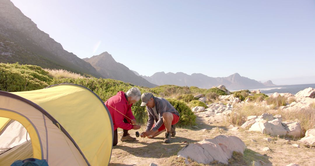 Senior Couple Setting up Tent in Mountain Landscape for Camping Adventure - Free Images, Stock Photos and Pictures on Pikwizard.com