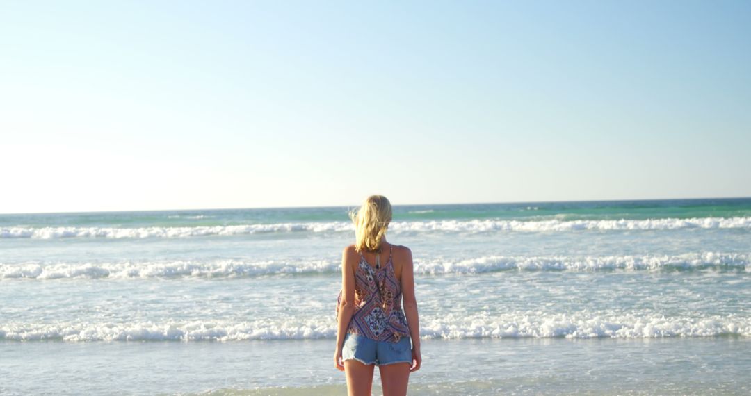 Woman Enjoying Tranquil Ocean View at Sunny Beach - Free Images, Stock Photos and Pictures on Pikwizard.com