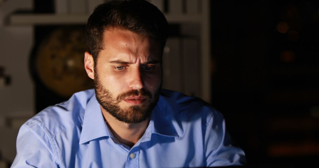 Worried Man Working Late at Office with Serious Expression - Free Images, Stock Photos and Pictures on Pikwizard.com